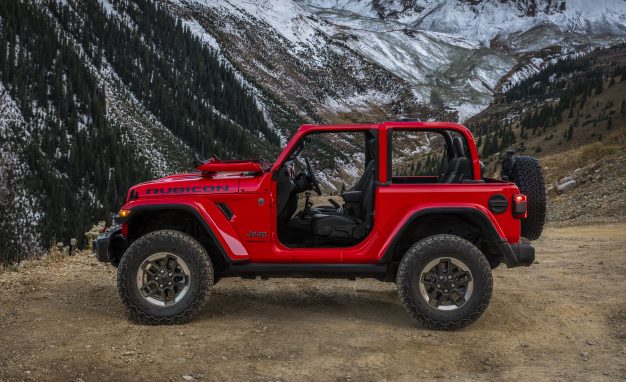 A 2018 JL Wrangler Rubicon, minus the roof and doors, with the windshield folded down.